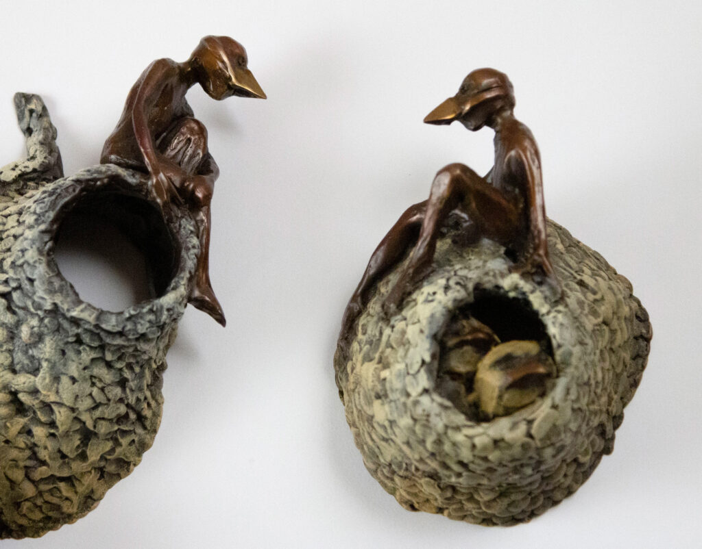 Bronze sculpture by Alicia Jones. This sculpture depicts a swallow colony with human invaders.