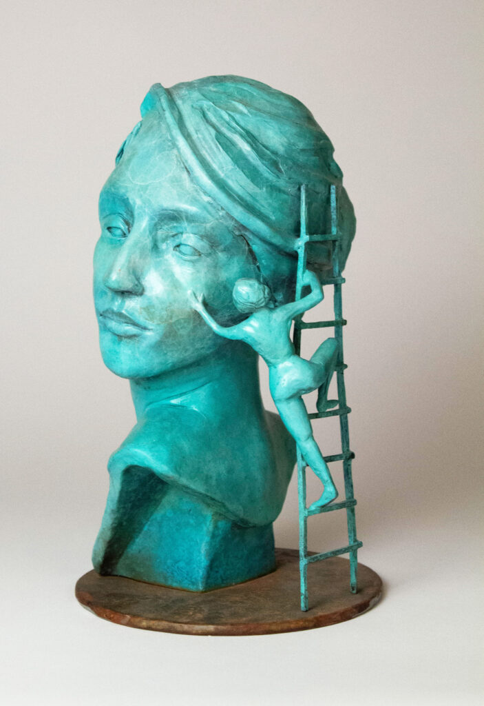 Bronze sculpture by of a woman's face with a smaller woman touching her cheek.