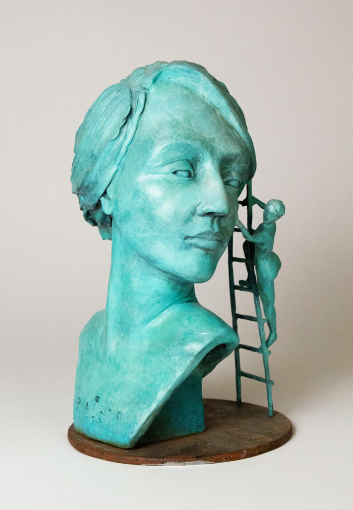 Bronze sculpture by of a woman's face with a smaller woman touching her cheek.